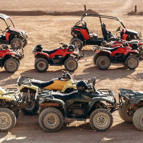 Large column of ATVs and buggies stands in the middle of a sandy desert. Ready for fun in the desert