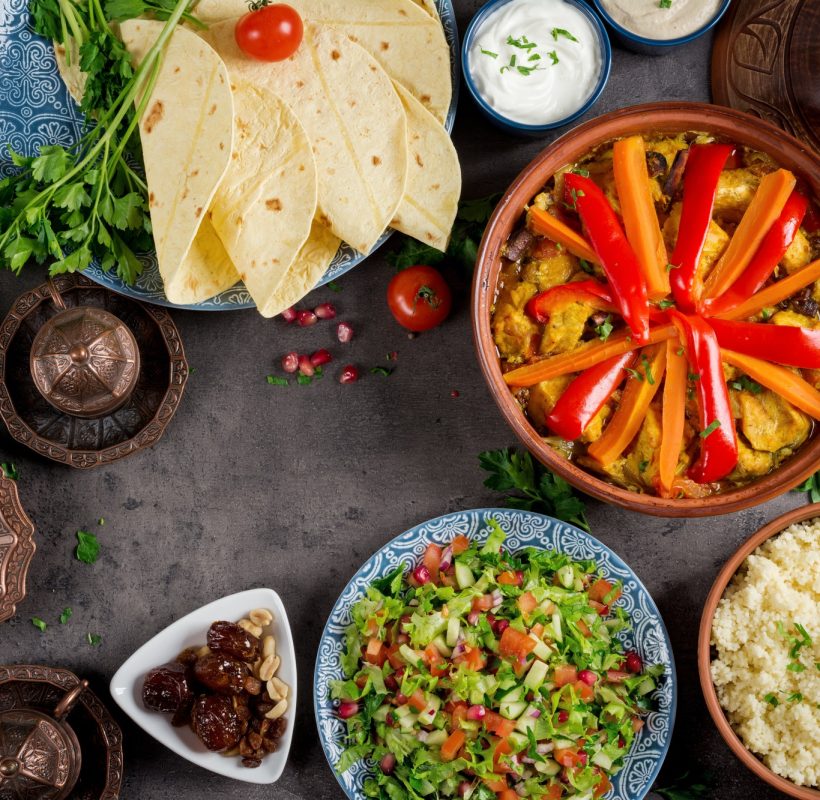 Moroccan food. Traditional tajine dishes, couscous and fresh salad on rustic wooden table. Moroccan food. Traditional tajine dishes, couscous and fresh salad on rustic wooden table.